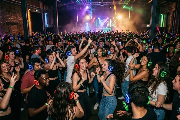 Silent disco event with crowd wearing glowing wireless LED headsets