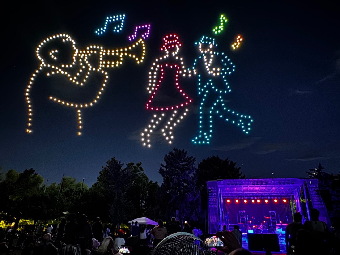 Drone light show over Salt Lake City crowd at night, colorful illuminated figures in the sky, audio production by SwissMixx Audio