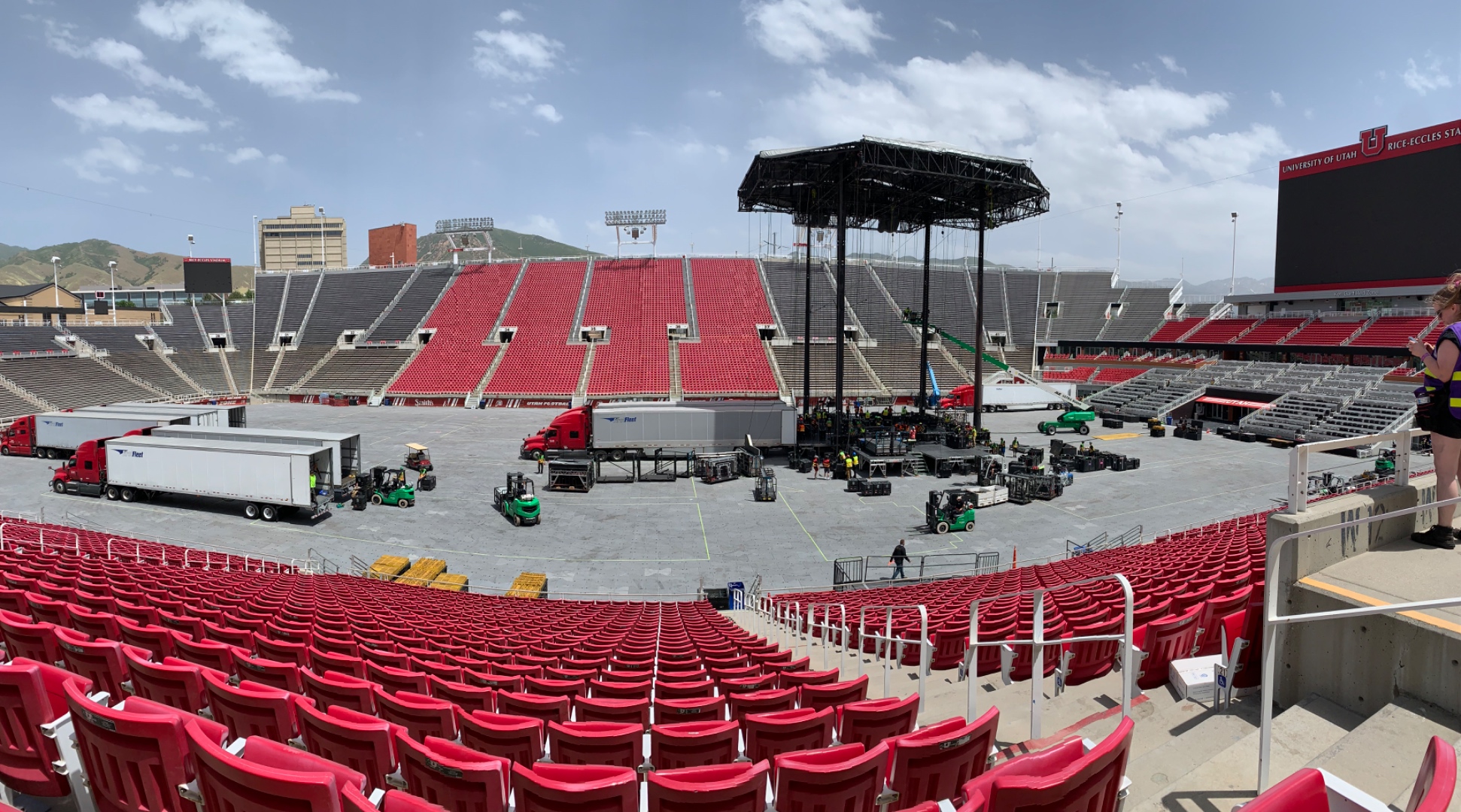Rice-Eccles Stadium during Garth Brooks production load-in -- semi trucks, forklifts, and full stage rig visible, SwissMixx Audio stadium crew