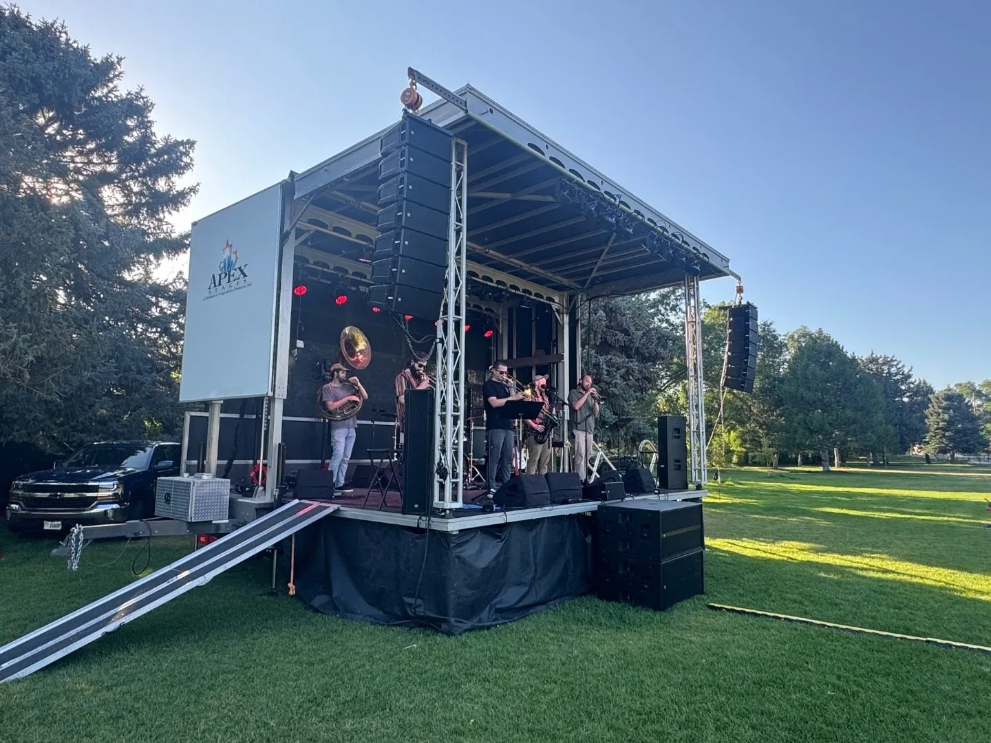 Live brass band with horn players performing on an outdoor stage, RCF line array PA by SwissMixx Audio, Idaho
