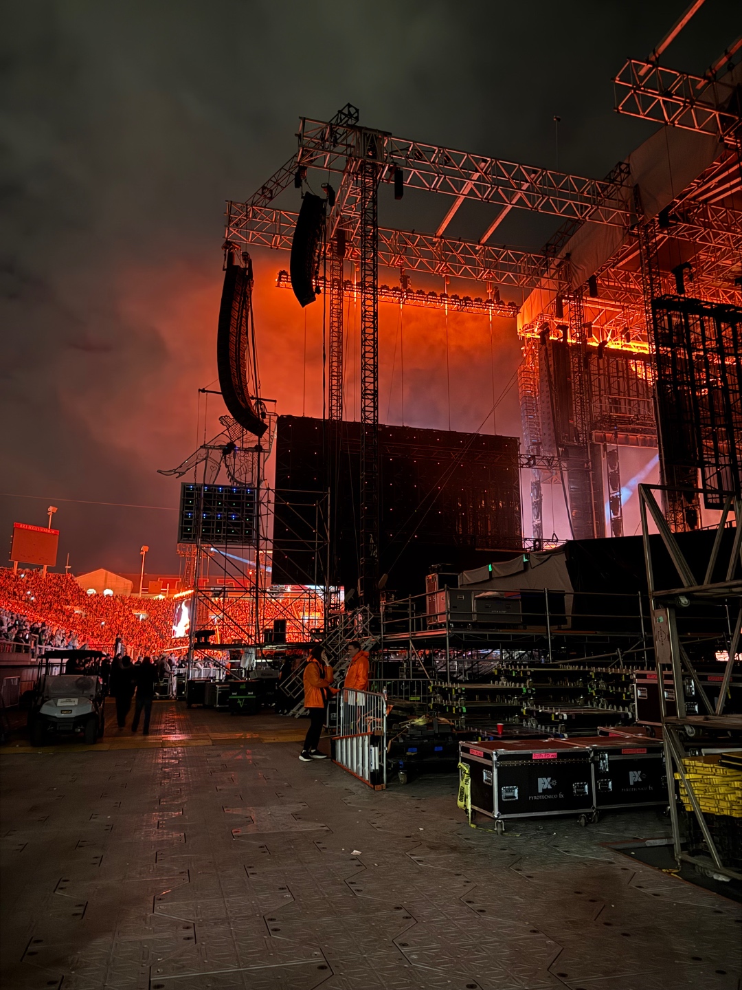 Side-stage view of the Post Malone concert at Rice-Eccles Stadium with line arrays, massive LED wall, smoke, and a sold-out crowd in orange and red light