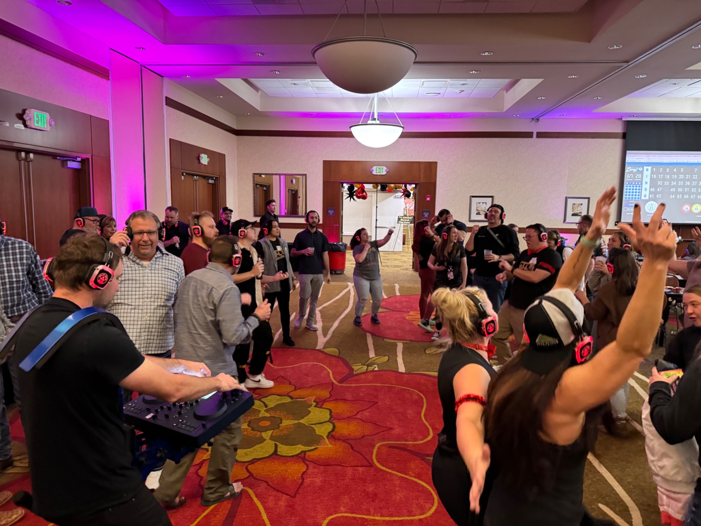 Silent disco event in hotel ballroom with DJ and guests wearing red LED headsets, SwissMixx Audio Boise Idaho