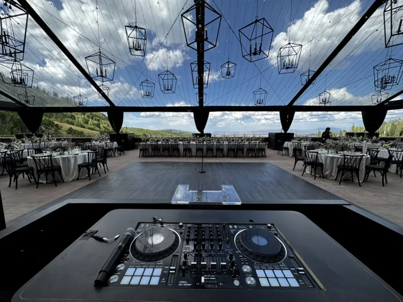 DJ decks overlooking an open air wedding venue with hanging lanterns and mountain views near Cascade Idaho, SwissMixx Audio